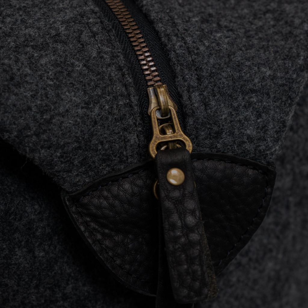 textured close up of dark wool bag with detailed zipper
